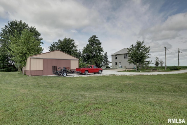 view of yard with a garage and an outbuilding