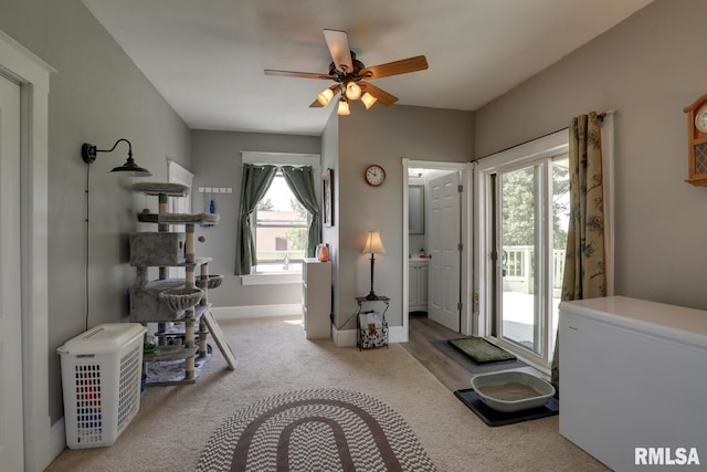 interior space with ceiling fan, a healthy amount of sunlight, light carpet, and heating unit