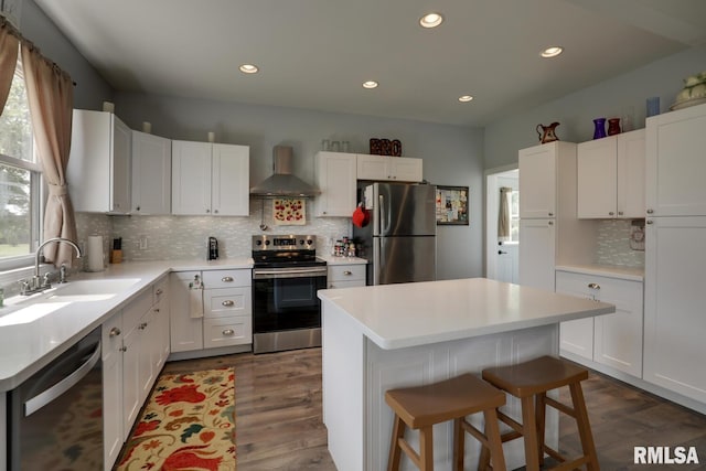 kitchen with backsplash, stainless steel appliances, a wealth of natural light, and wall chimney range hood