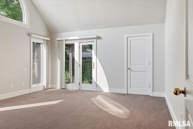 carpeted empty room with high vaulted ceiling