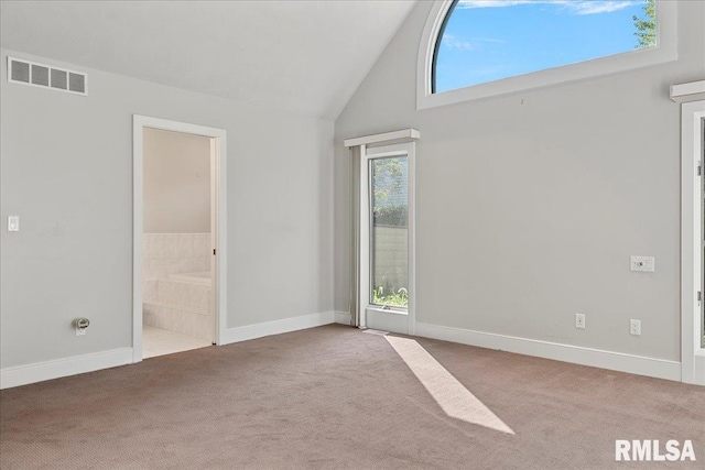 carpeted empty room featuring high vaulted ceiling