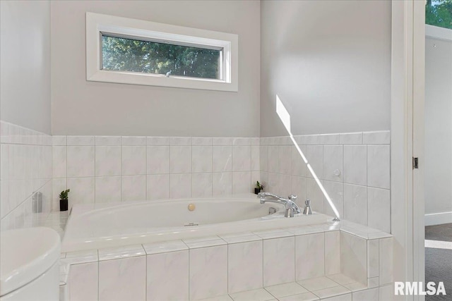 bathroom featuring plenty of natural light and tiled tub