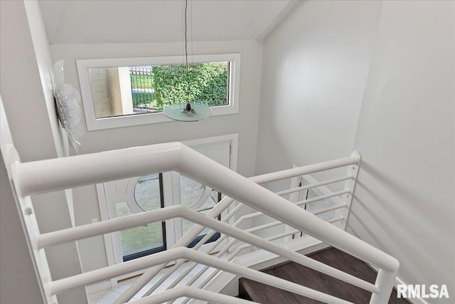 staircase featuring a towering ceiling and an inviting chandelier