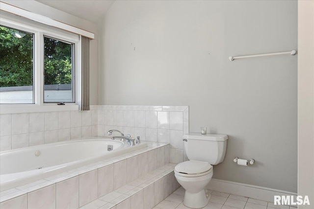 bathroom with tile patterned floors, toilet, and tiled tub