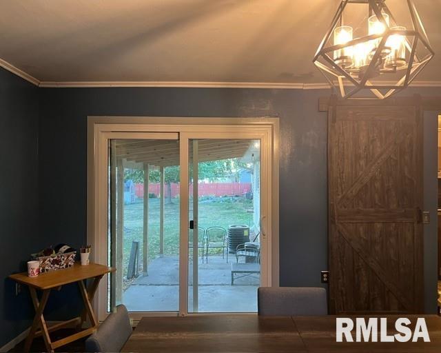 doorway featuring ornamental molding, a chandelier, and hardwood / wood-style floors