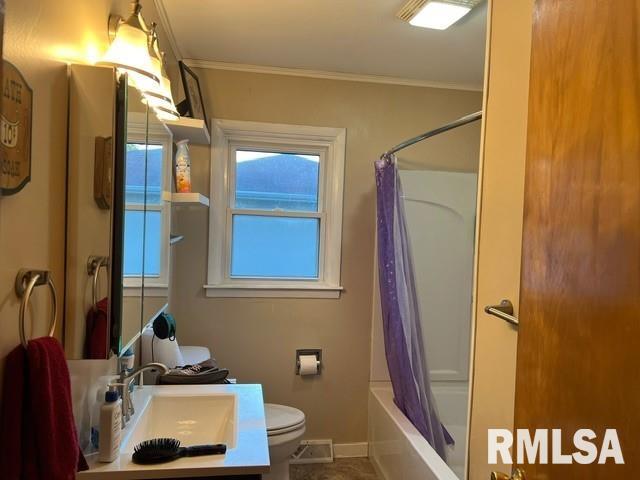 full bathroom featuring toilet, crown molding, vanity, and shower / tub combo