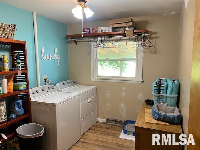 laundry area featuring ceiling fan, washing machine and dryer, and light wood-type flooring