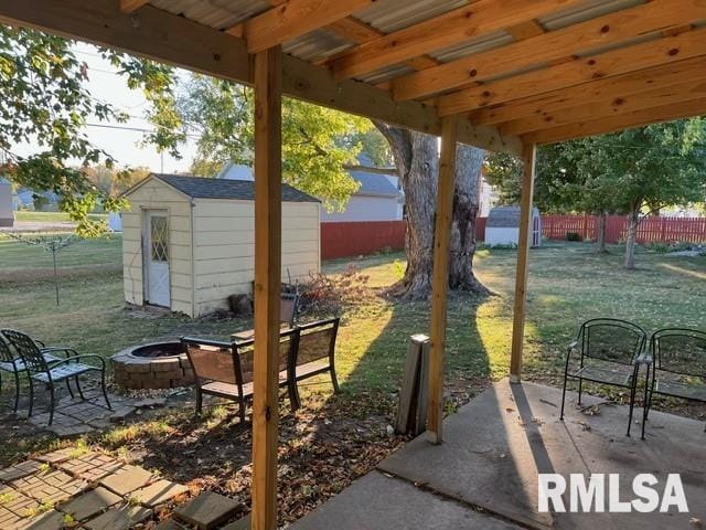 view of patio / terrace featuring an outdoor fire pit and a shed