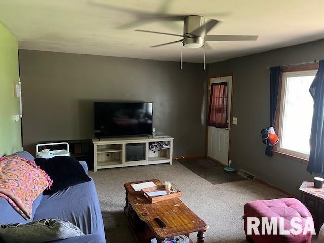 carpeted living room with ceiling fan