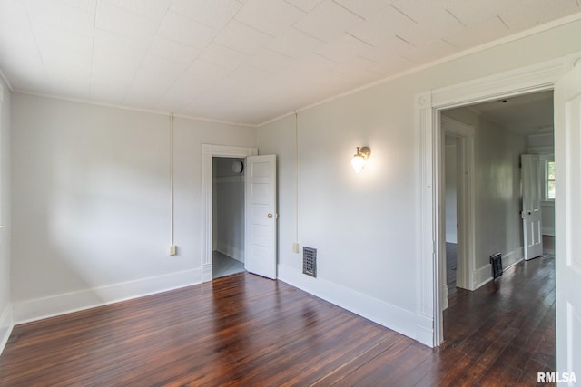 empty room with dark hardwood / wood-style floors and ornamental molding