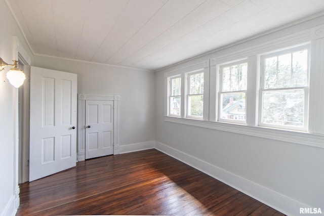 spare room with dark hardwood / wood-style floors and ornamental molding