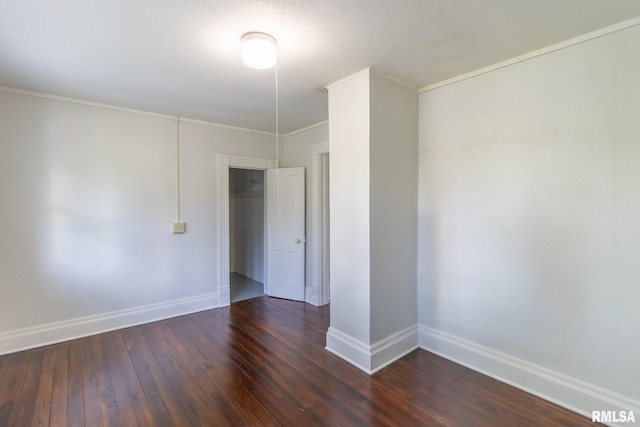 unfurnished room with a textured ceiling, ornamental molding, and dark hardwood / wood-style floors