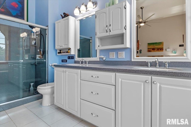 bathroom with vanity, ceiling fan, tile patterned flooring, toilet, and a shower with shower door