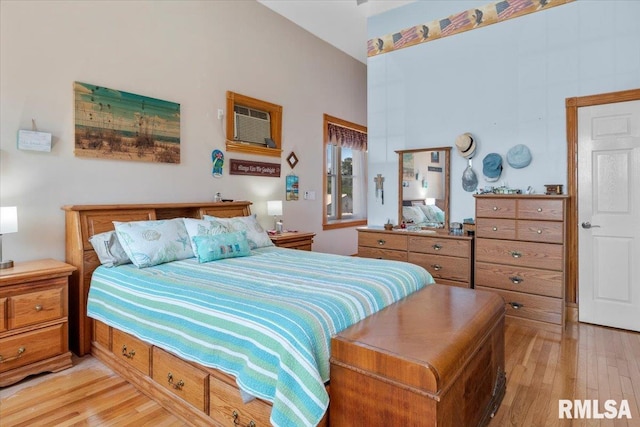 bedroom featuring an AC wall unit and light hardwood / wood-style flooring