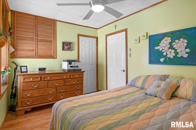 bedroom featuring ceiling fan, crown molding, and light hardwood / wood-style flooring