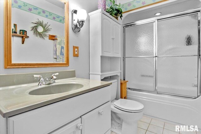 full bathroom featuring shower / bath combination with glass door, tile patterned flooring, vanity, and toilet