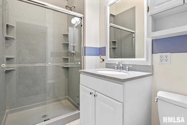 bathroom with a shower with door, vanity, and toilet