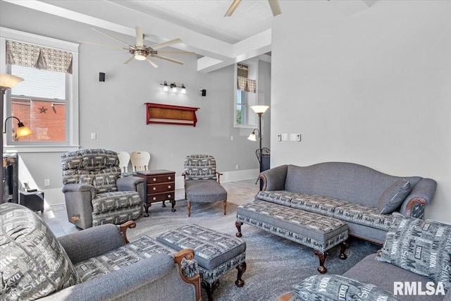 living room with beamed ceiling, carpet, and ceiling fan