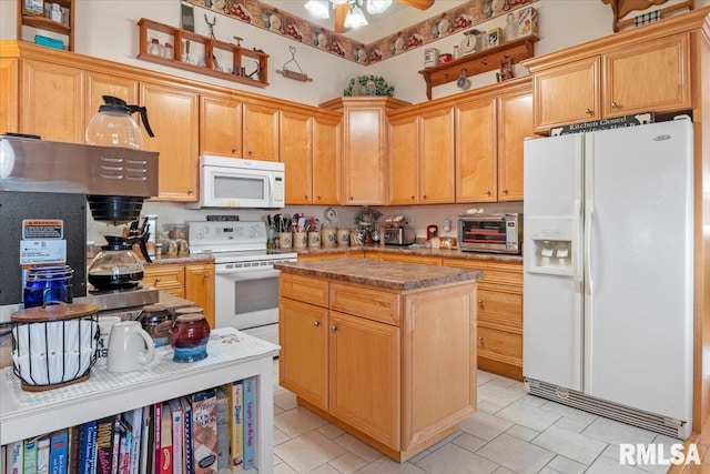 kitchen with light brown cabinetry, white appliances, a kitchen island, and ceiling fan