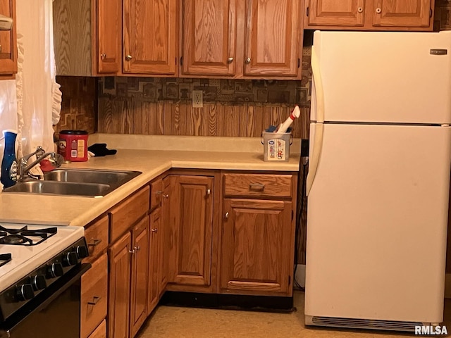 kitchen with white appliances, backsplash, and sink