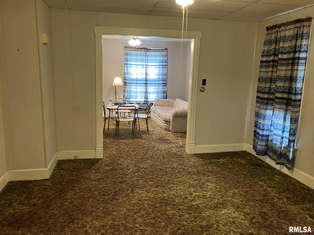 hallway featuring a drop ceiling and carpet