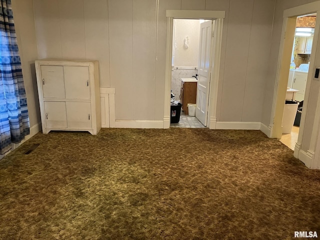 unfurnished bedroom with ensuite bath and light carpet