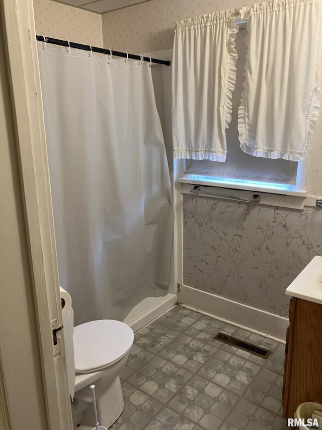 bathroom with vanity, toilet, and curtained shower