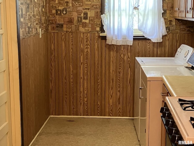 laundry room featuring carpet flooring, independent washer and dryer, and wooden walls