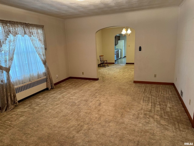 carpeted empty room with radiator heating unit, crown molding, an inviting chandelier, and a textured ceiling