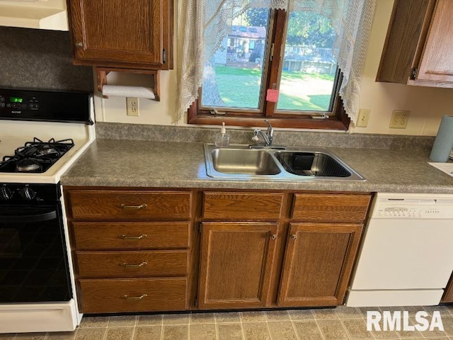 kitchen featuring white appliances, sink, and range hood