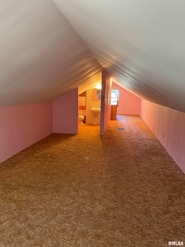 additional living space featuring lofted ceiling and carpet flooring