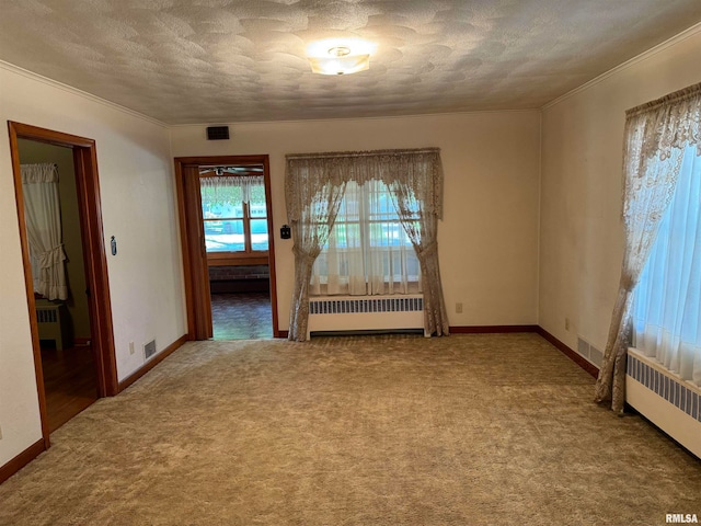 empty room featuring radiator, a textured ceiling, and carpet flooring