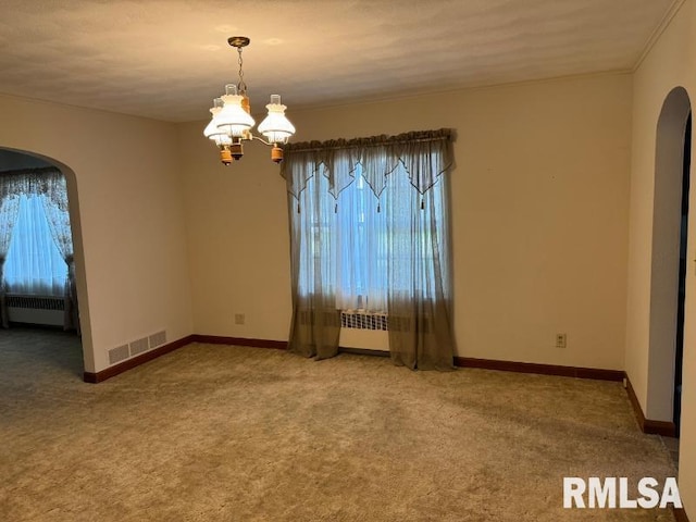 carpeted spare room with radiator and an inviting chandelier