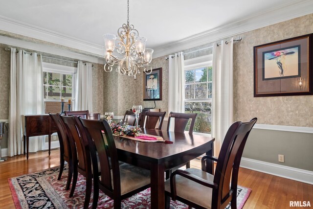 dining area with ornamental molding, wood-type flooring, and a notable chandelier