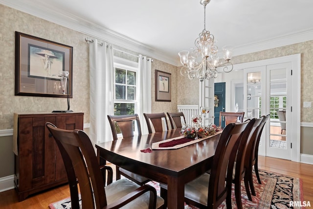 dining space with wallpapered walls, crown molding, and light wood-style flooring