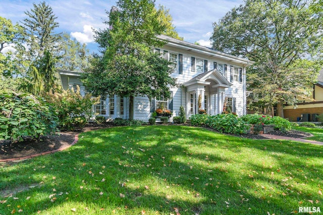 colonial-style house featuring a front lawn