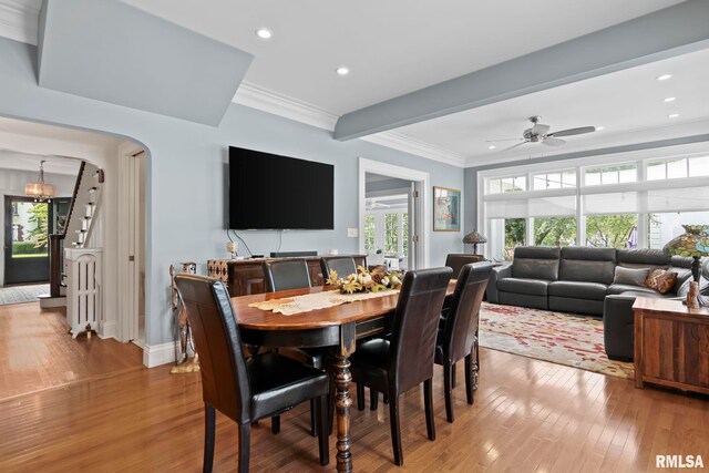 dining room with ceiling fan, ornamental molding, wood-type flooring, and beam ceiling