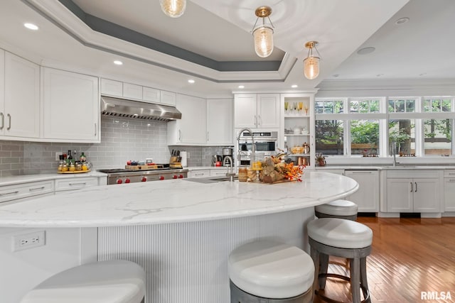 kitchen with light hardwood / wood-style floors, white cabinets, and hanging light fixtures