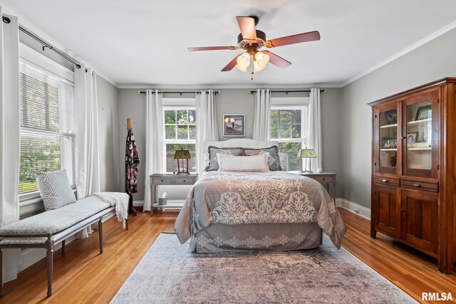 bedroom with crown molding, ceiling fan, and hardwood / wood-style flooring