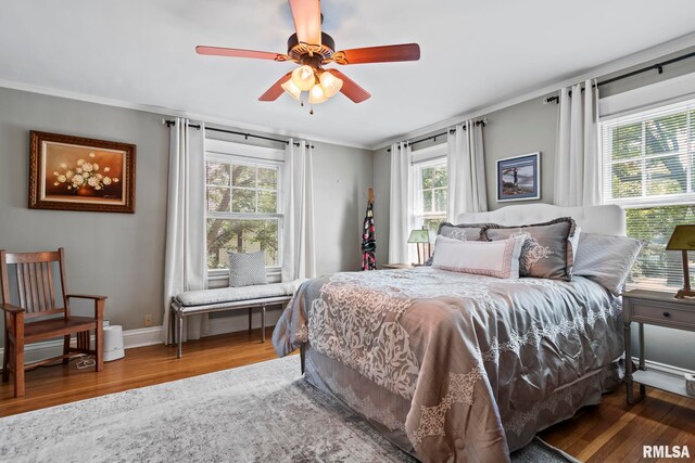 bedroom with crown molding, ceiling fan, and hardwood / wood-style floors