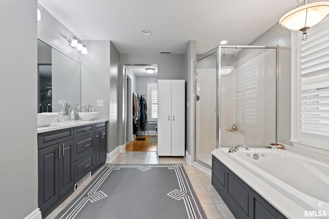 full bathroom featuring tile patterned floors, a garden tub, a shower stall, and a sink