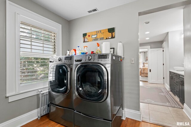 laundry area with light wood-type flooring and washer and dryer