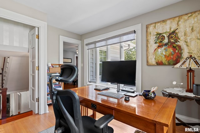 office area with light wood finished floors and a ceiling fan