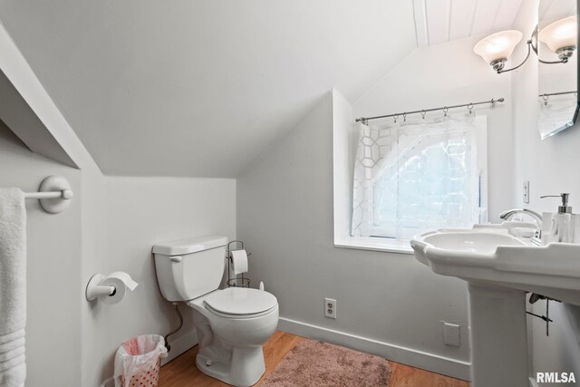 bathroom with hardwood / wood-style flooring, lofted ceiling, and toilet