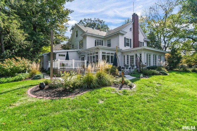 rear view of house with a lawn and a deck