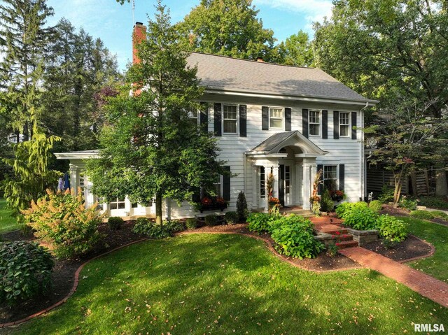 colonial inspired home featuring a front lawn