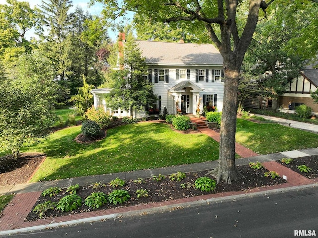 view of front of home featuring a front lawn and a chimney