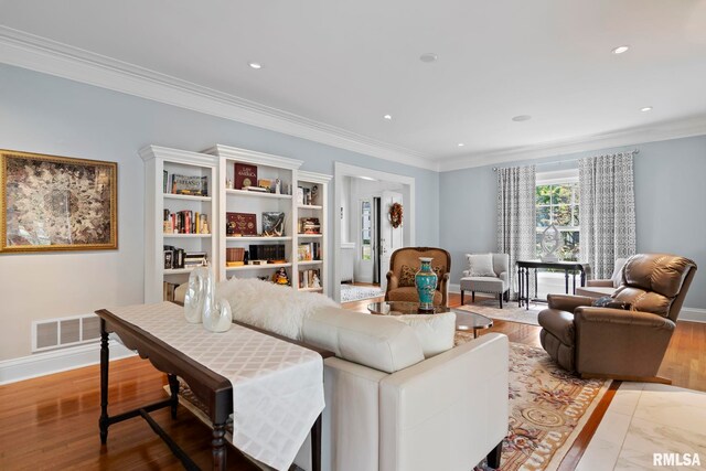 living room with hardwood / wood-style floors and crown molding