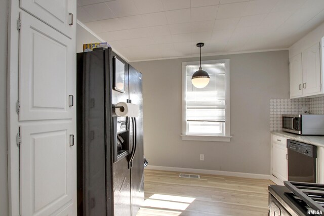 kitchen with light wood-type flooring, crown molding, white cabinetry, black appliances, and hanging light fixtures