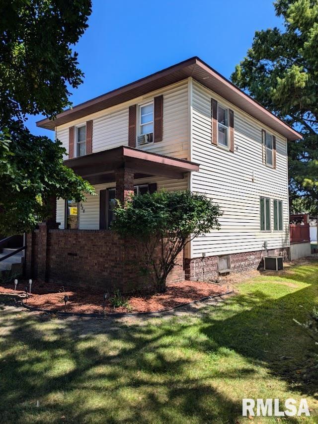 view of front of house featuring a front lawn and central AC unit